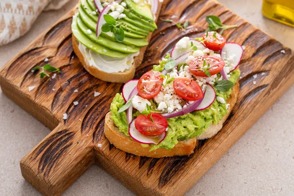 Whole grain bread with mashed avocado and tomatoes