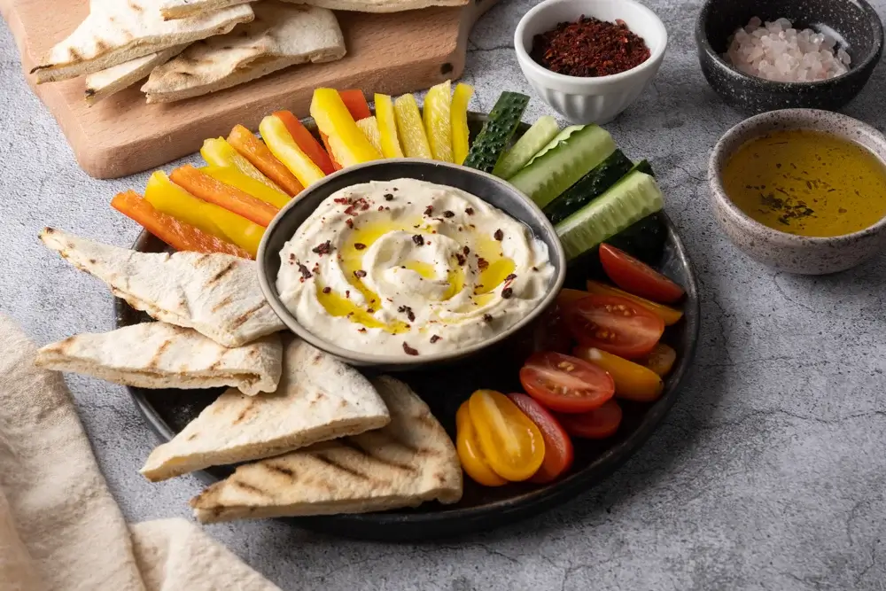 Hummus, whole-grain pita, and a large vegetable plate. 
