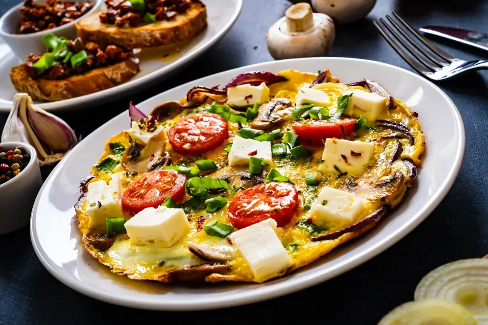 Vegetable omelet with spinach, mushrooms, tomatoes, and feta cheese. 