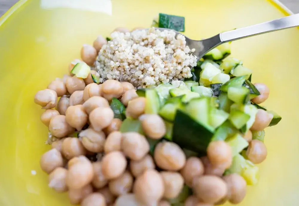 Quinoa bowl with chickpeas, cucumber, spinach, and tahini dressing. 