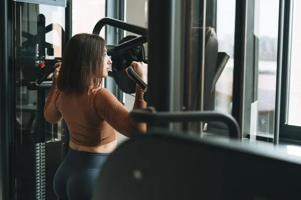 Woman working out at the gym, working on back muscles