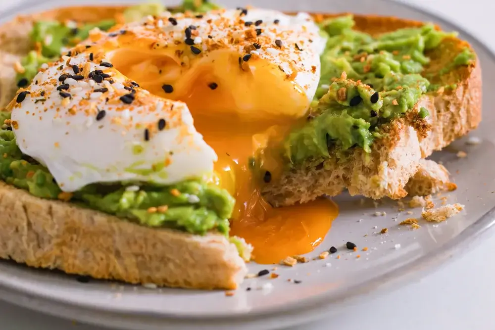 Whole-grain toast with mashed avocado, poached eggs,