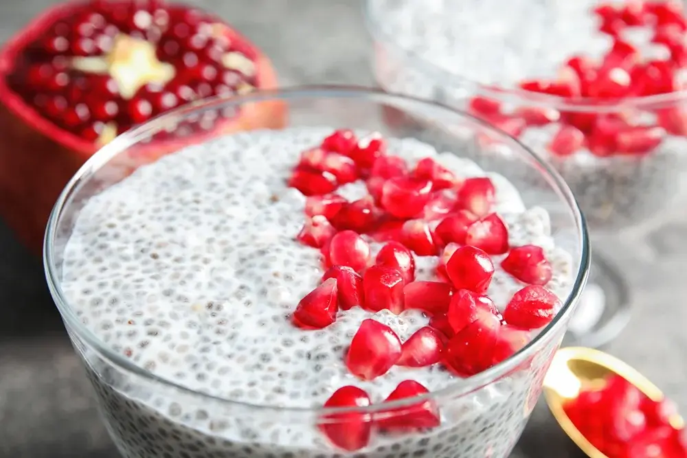 Chia pudding made with coconut milk, topped with pomegranate seeds.